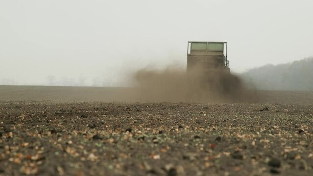 Fertilizing fields with compost. Fertilization of earth with organic fertilizers mechanically. Agricultural work in the fields. Fertilizing the land after harvest. Farmer Spreading Organic Manure