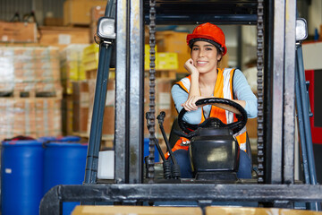 female worker smiling and sitting on forklift in warehouse storage