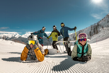 Group of happy young friends skiers and snowboarders are having fun and posing for photo at ski...