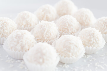 Candies with coconut flakes. Selective focus.White background.