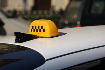 Taxi top sign on car roof on road background, transportation in city