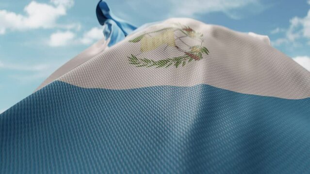 Wavy flag of Guatemala blowing in the wind in slow motion. Waving colorful Guatemalan flag team symbol abstract vertical background. Blue sky with clouds. World countries flying flags concept