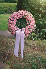 Pink funeral rose wreath on the cemetery.