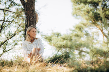 Adult woman artist sitting in the park holding a sketchbook