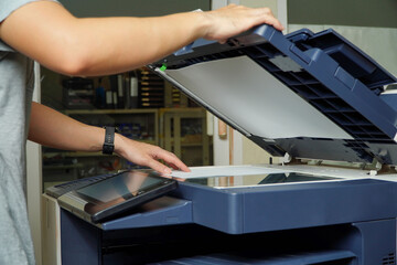 Young Asian businessman using a photocopier, printer scanner laser office copy machine supplies start concept.