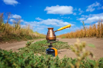 Fototapete Dhaulagiri Copper cezve on a gas burner outdoors under a blue sky. Coffee in nature