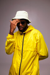 Surprised african american man in stylish bright clothes and sunglasses standing isolated on grey