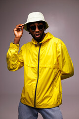 Fototapeta premium Shocked african american man in sunglasses and bright streetwear standing isolated on grey