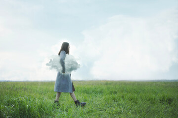 woman walking under her arm a cloud in a field, abstract concept