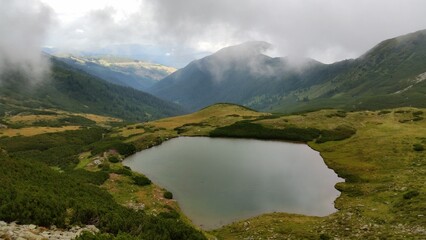 A tranquil gem, nestled amidst towering peaks, reflecting their majesty in its crystal clear waters..