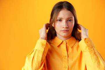 Upset disturbed teen girl on yellow background