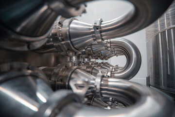 Industrial pipeline elbow system. Large, thick exchanger stainless steel pipes. Bent pipes are connected by flanges