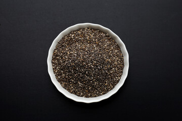 Chia seeds on dark background.