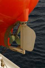 Propeller and rudder of a life boat secured onboard a merchant ship at sea