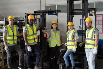Group of male and female warehouse worker in safety vest and helmet working in industry storage...