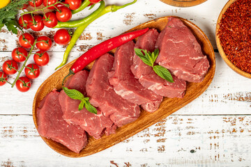 Raw beef tenderloin on wood background. Raw beef tenderloin with herbs and spices. Top view
