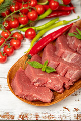Raw beef tenderloin on wood background. Raw beef tenderloin with herbs and spices