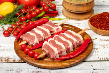 Raw lamb tenderloin on wood background. Raw lamb tenderloin with herbs and spices