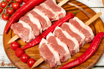 Raw lamb tenderloin on wood background. Raw lamb tenderloin with herbs and spices. Close up