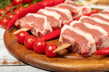 Raw lamb tenderloin on wood background. Raw lamb tenderloin with herbs and spices. Close up