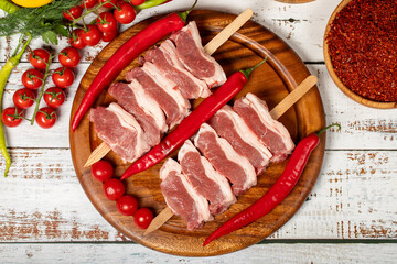 Raw lamb tenderloin on wood background. Raw lamb tenderloin with herbs and spices. Top view