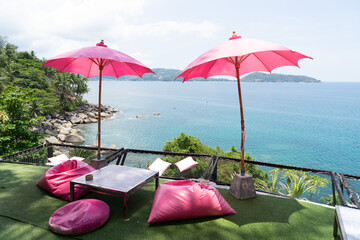 Two pink umbrellas in a cafe with a sea view are perfect for relaxing.