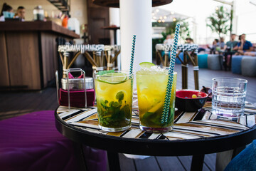 Alcohol yellow green mojito cocktails with citrus lime in glasses on a table A juicy fresh...