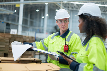Employees are inspecting products in the factory. They are working together in the building.