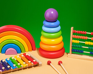 Concept of the bright and fun childhood. Pyramid with colored rings, xylophone, abacus and rainbow.