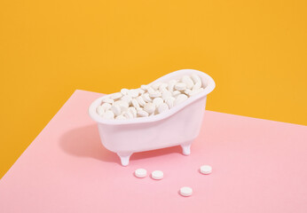 A small stand in the shape of a white tub filled with white tablets to cure illnesses. Vitamins and supplements.