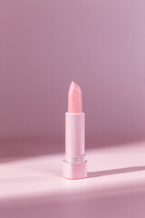 Pink pearlescent lipstick on a pink background