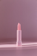 Pink pearlescent lipstick on a pink background