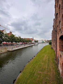 Kanal in Lübeck mit Blick auf Backsteinhäuser und Außengastronomie
