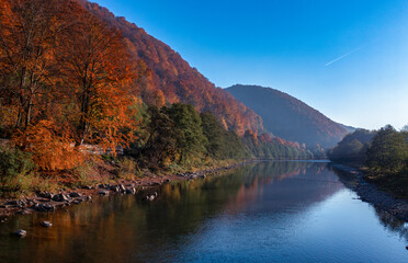 Fototapeta na wymiar Autumn's Embrace: Mountain Lake Amidst Fall-Foliage Hills