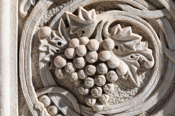 Grape carved in white stone , close up details