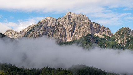 A mountain top reaching above the clouds in the Julien Alps in Slovenia