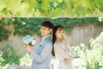 A loving couple is taking wedding photos outdoors for their wedding.