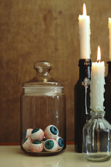Obraz na płótnie Canvas halloween still life with a jar of eyeballs and glowing candles