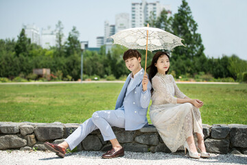 A loving couple is taking wedding photos outdoors for their wedding.