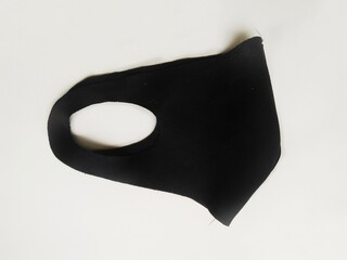 Folded Black Scuba fabric face mask on white background. Protection face mask for prevent dust, flu or covid-19 virus. Reusable and washable fabric mask