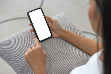Close up image of female hands using smartphone with blank white screen in the home