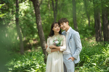 A loving couple is taking wedding photos outdoors for their wedding.