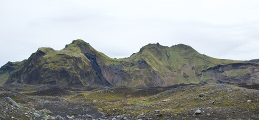 Small inselbergs covered with green grass in Hafursey, Iceland