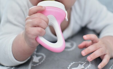 baby holds a pacifier for fruits and vegetables in his mouth
