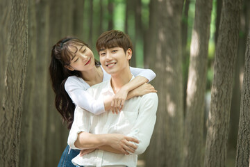 Fototapeta premium A lovely young couple are having fun in a forested park.