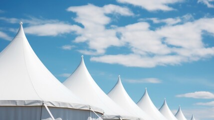 Row of white tent tops under a blue sky background. - obrazy, fototapety, plakaty