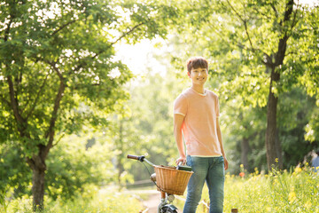 A young man is riding a bicycle in the park.