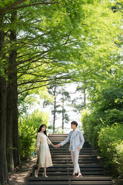 A loving couple is taking wedding photos outdoors for their wedding.