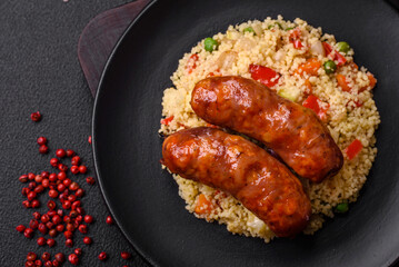 Delicious chicken or pork sausages baked on the grill with porridge and vegetables
