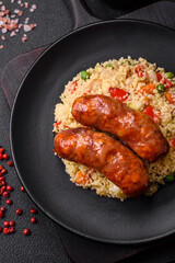 Delicious chicken or pork sausages baked on the grill with porridge and vegetables